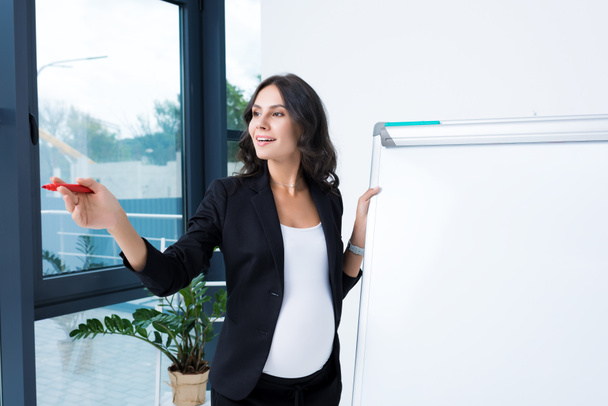 pregnant businesswoman with blank whiteboard - Фото, изображение