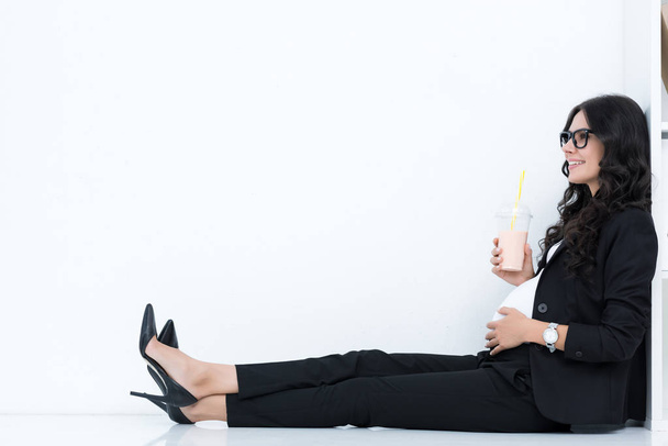 pregnant businesswoman drinking milkshake - 写真・画像