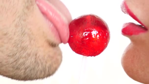 sexy paar man en vrouw eten een lolly. simulatie van orale seks. tong likken snoep. 4k, slow-motion-video kopiëren ruimte. kus - Video