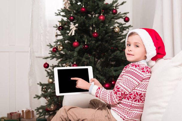 chico apuntando a la tableta en Navidad
 - Foto, imagen
