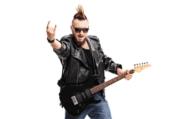 Punker with an electric guitar making a rock hand gesture - Fotografie, Obrázek