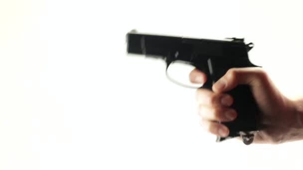 Homem dispara uma arma preta em um fundo branco
 - Filmagem, Vídeo