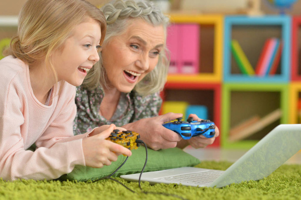 Бабуся і онука грають на ноутбуці
 - Фото, зображення