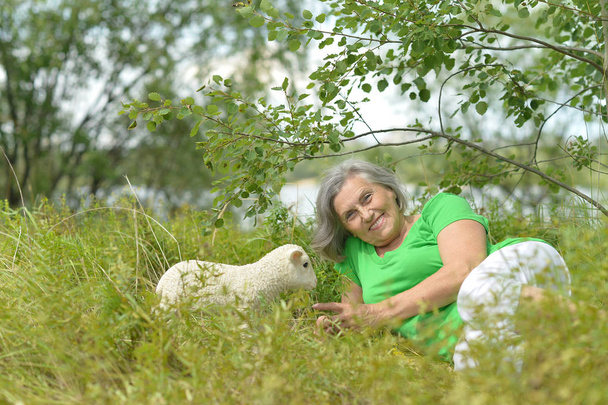 Senior woman   with toy sheep - Fotó, kép