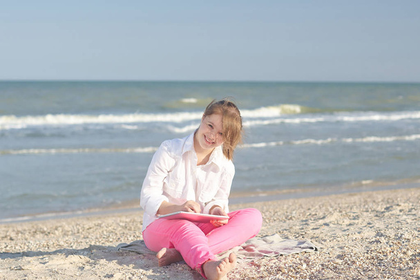 Girl seventeen-year-old  with Down syndrome on the beach play wi - Φωτογραφία, εικόνα