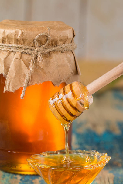 Honey in a pot or jar on kitchen table - Fotó, kép