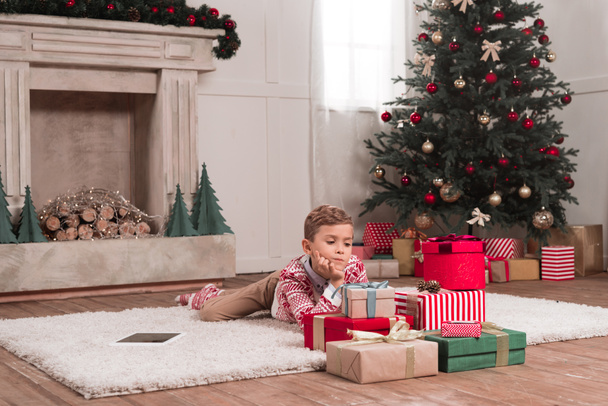 garçon posé sur le sol avec des cadeaux de Noël
 - Photo, image