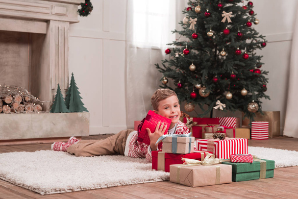 boy laying on floor with christmas gifts - Foto, Bild