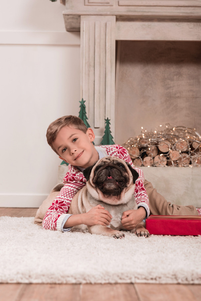 boy with christmas gift and pug - Foto, imagen
