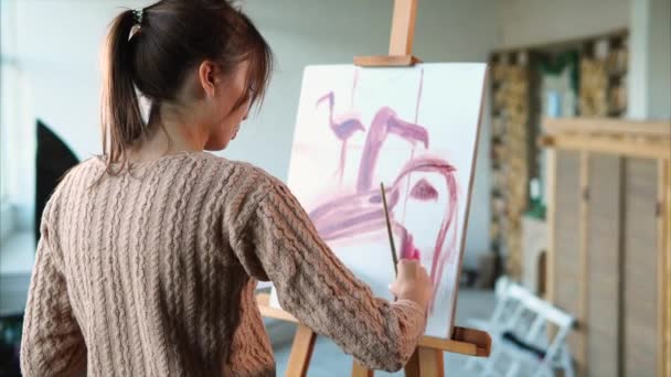 Nainen maalaa nopeita aivohalvauksia vaaleanpunainen flamingot eri näkökulmista, hän käyttää harjaa
 - Materiaali, video