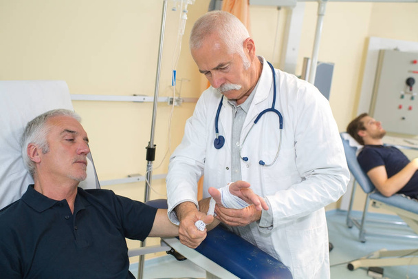 doctor bandaging male patients wrist - Foto, Imagem