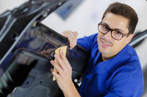 young service mechanic cleaning automobile car door - Photo, Image