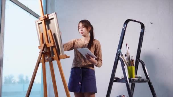 Joven hermosa chica está dibujando una pintura interior
. - Metraje, vídeo