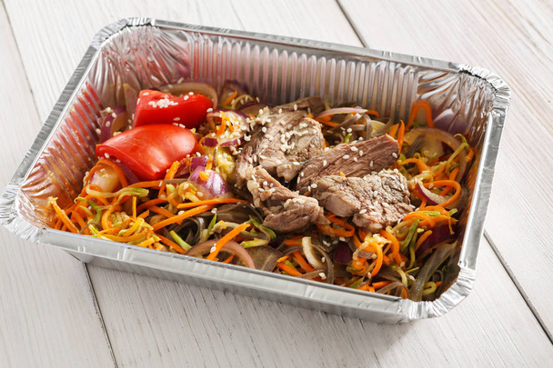 Healthy food take away in foil box closeup, steamed meat with salad - Photo, Image