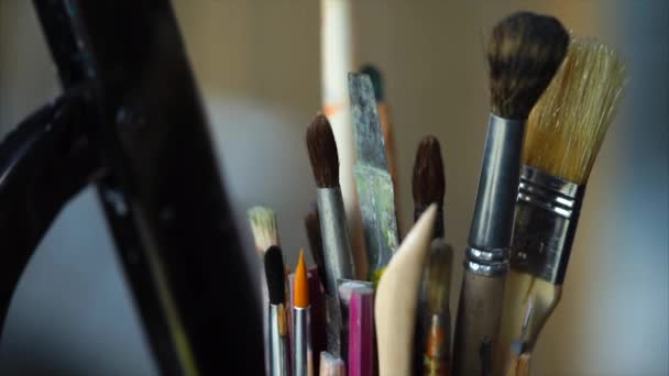 Close-up tiro de um copo com escovas de tamanhos diferentes, que pertencem ao artista
 - Filmagem, Vídeo