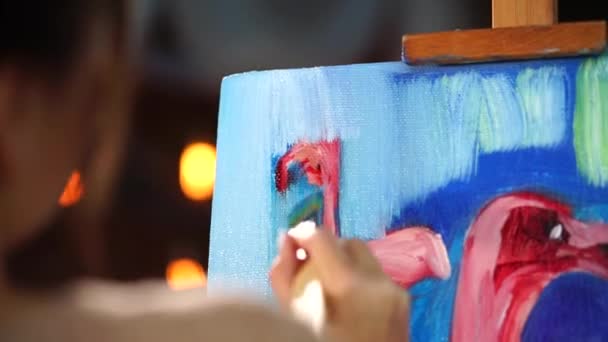 Fiatal festő befejező van a háttérben, az ő festmény. - Felvétel, videó