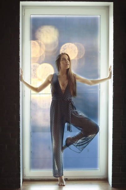 woman standing against window  - Фото, изображение