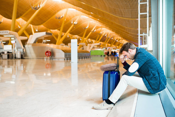 Uomo sconvolto, triste e arrabbiato con l'aeroporto il suo volo è in ritardo
 - Foto, immagini