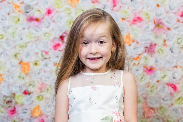 Портрет маленькой девочки на цветочном фоне
      - Фото, изображение