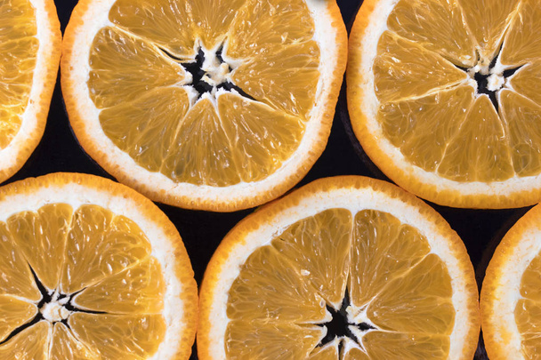 Citrus-gyümölcs, narancs szeletek absztrakt háttér. Sötét háttér előtt. Közelről. Fotóstúdió. - Fotó, kép