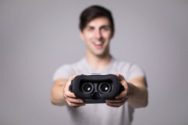 Man wearing virtual reality goggles. Studio shot, gray background - Fotoğraf, Görsel