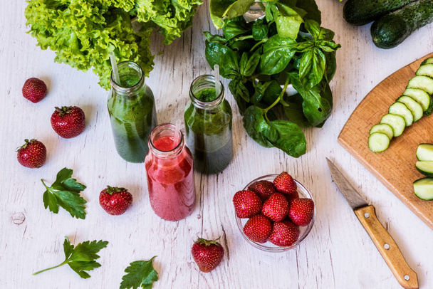 Fresh green smoothies and strawberry smoothie with ingredients on a light wooden background. Healthy detox drinks. - Fotografie, Obrázek