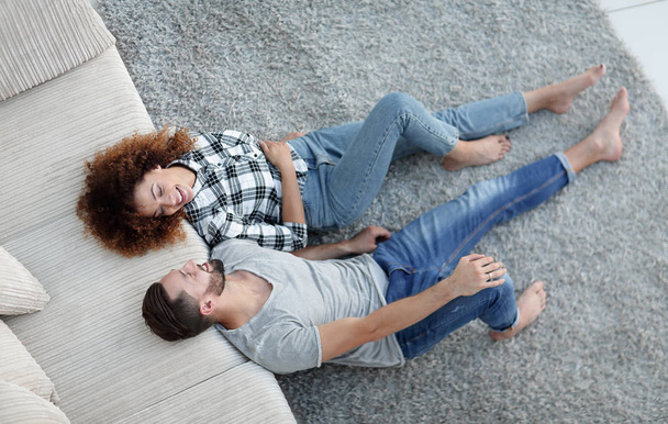 mosolygó pár feküdt egy szőnyeg egy új lakás - Fotó, kép