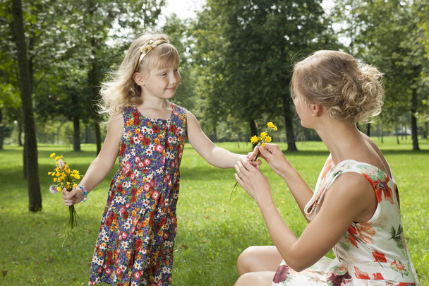 Girl gives a flowers mother - Φωτογραφία, εικόνα