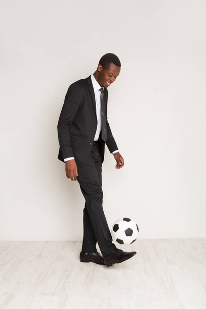 Succesvolle jonge zwarte zakenman in officiële pak, stropdas, spelen bal - Foto, afbeelding