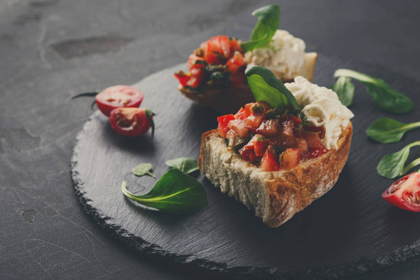 Bruschetta with cheese and vegetables on black background - Фото, зображення