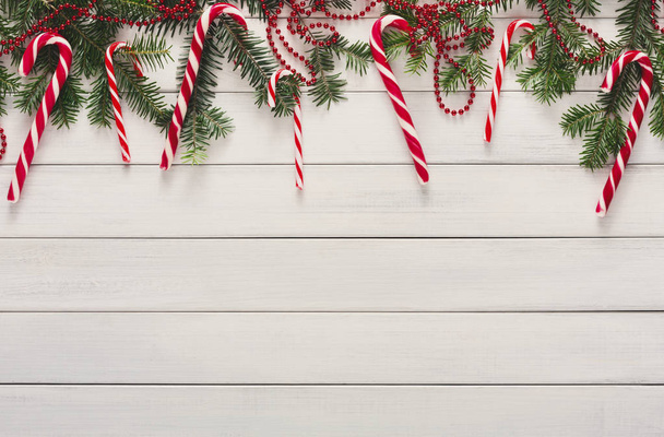 Kerstmis achtergrond met snoepjes en fir tree grens op hout - Foto, afbeelding