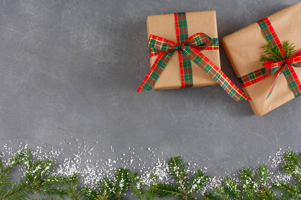 Різдвяні подарункові коробки ручної роботи, вид зверху, копіювання простору на сірому фоні столу. Ялинка, прикрашений сніг
 - Фото, зображення