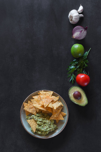 Plate of guacamole with tortilla chips and ingredients - Foto, Imagen