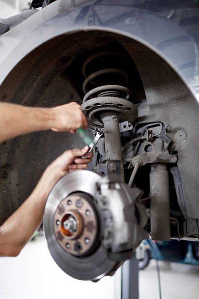 An unidentified mechanic repairing brake pads with tools - Foto, Imagem