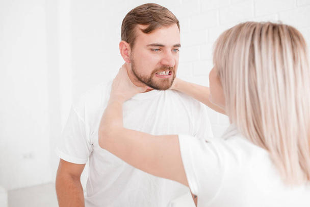 A girl is strangling a man on a white background - Foto, afbeelding