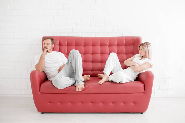 Un hombre y una niña están sentados en un sofá sobre un fondo blanco
 - Foto, Imagen