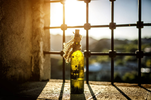 Vecchia, polverosa bottiglia di vino sul davanzale della finestra, la luce del sole. - Foto, immagini