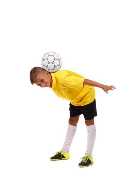 Kid having fun with a ball. Young football player isolated on a white background. Sports equipment concept. - Foto, Imagem