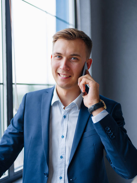 Happy business manager talking on a phone on a blurred background. Technology concept. - Fotografie, Obrázek