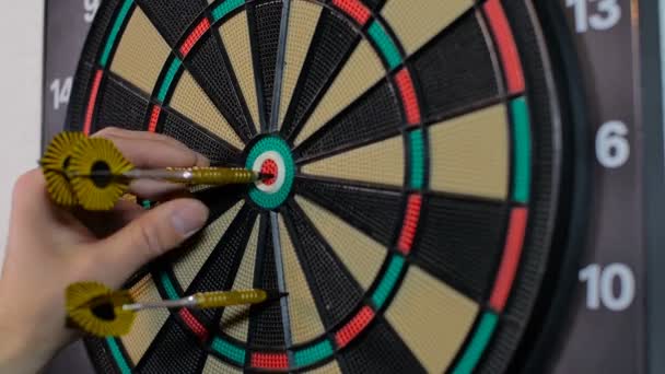 Man pulls out yellow darts from the board - Footage, Video