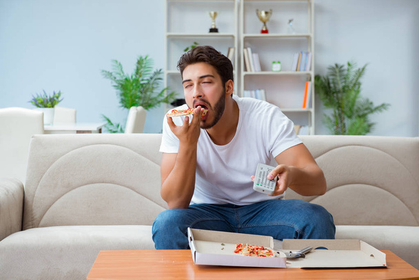 Man eating pizza having a takeaway at home relaxing resting - Foto, Imagem