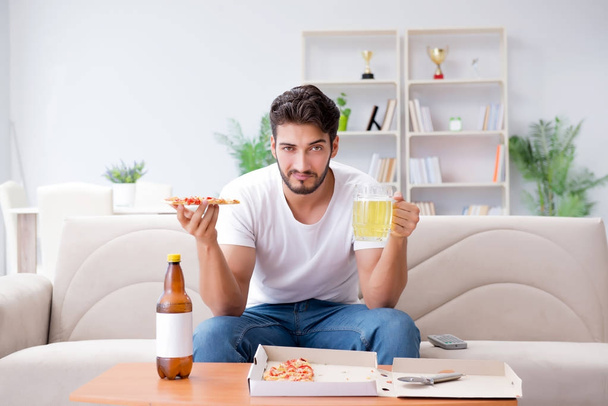 Man eating pizza having a takeaway at home relaxing resting - Foto, imagen