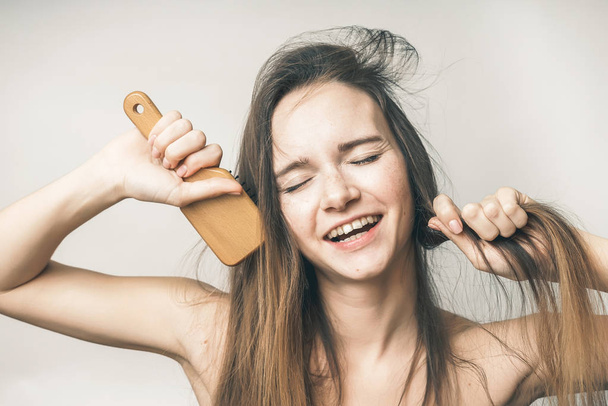 Funny woman singing with comb, beautiful long hair - Foto, Imagen