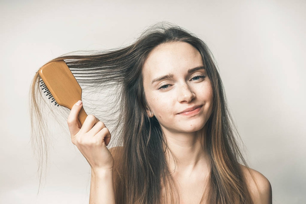 Teenager with hair comb,no problems, the girl is looking at the camera - Fotografie, Obrázek