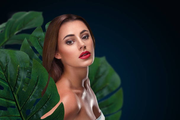 Young woman with perfect skin within tropical foliage - Fotoğraf, Görsel