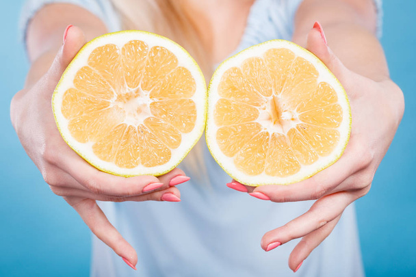 Halfs of yellow grapefruit citrus fruit in human hands - Фото, изображение