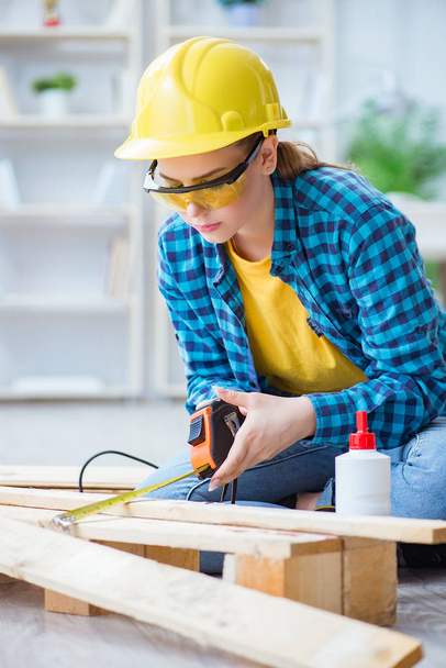 Женщина-ремонтница плотник режет соединительные деревянные доски - Фото, изображение