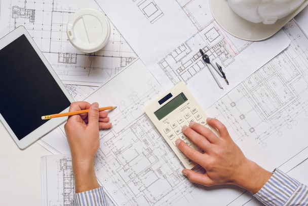 architect working with blueprints and calculator - Фото, зображення