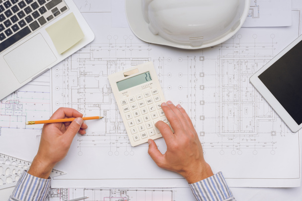 architect working with blueprints and calculator - Photo, Image