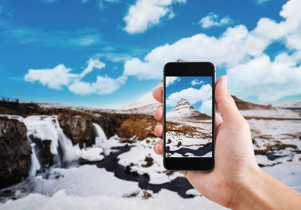 Tomando paisaje de montaña Kirkjufell en invierno por teléfono inteligente móvil
 - Foto, imagen